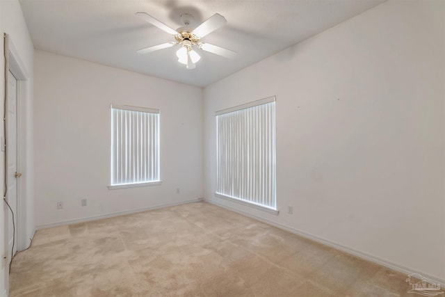 unfurnished room featuring light colored carpet, ceiling fan, and baseboards