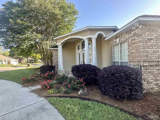 view of side of property with stucco siding and brick siding