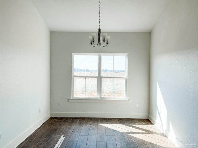 unfurnished room with hardwood / wood-style flooring and a notable chandelier