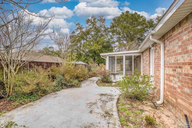 view of yard featuring a patio and a sunroom