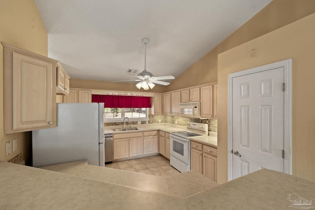 kitchen featuring white appliances, tasteful backsplash, lofted ceiling, ceiling fan, and sink