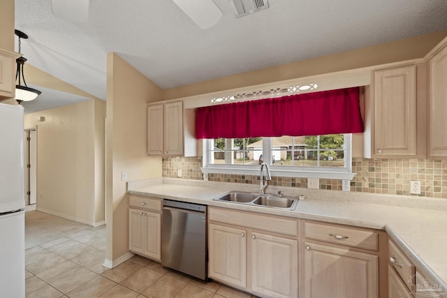 kitchen featuring light tile patterned floors, white refrigerator, sink, stainless steel dishwasher, and backsplash