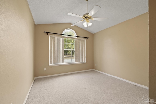 carpeted spare room with a textured ceiling, ceiling fan, and vaulted ceiling