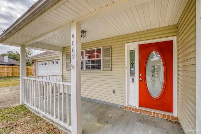 entrance to property with covered porch and a garage