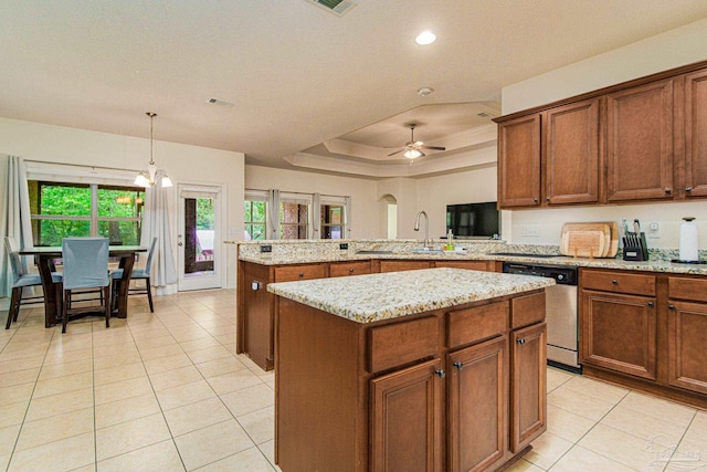 kitchen with kitchen peninsula, dishwasher, a center island, a tray ceiling, and sink