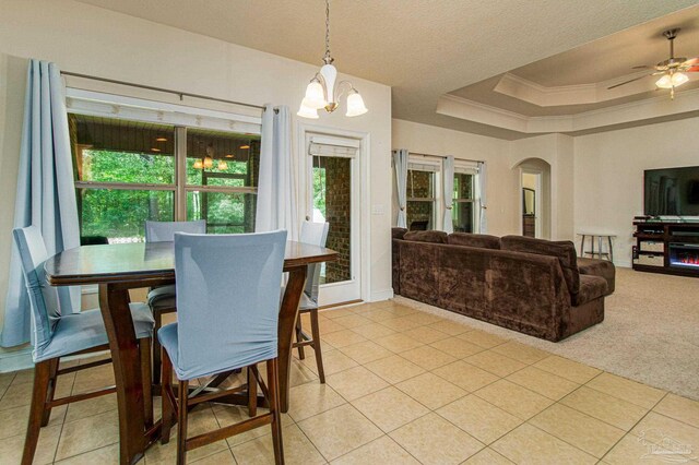 dining space with ceiling fan with notable chandelier, a raised ceiling, and light colored carpet