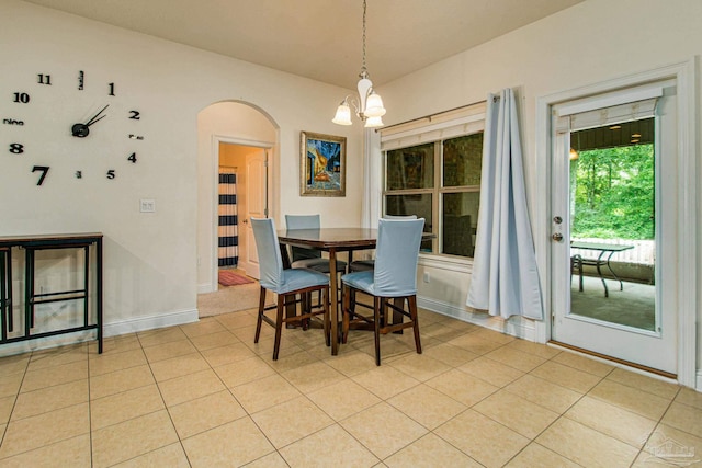 tiled dining room featuring a chandelier