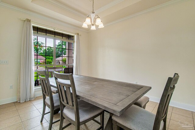 tiled dining room with a chandelier and a tray ceiling