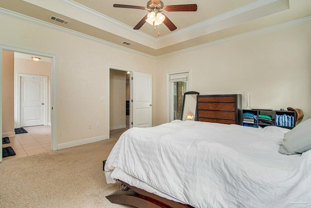 bedroom with ceiling fan, light carpet, ornamental molding, and a tray ceiling