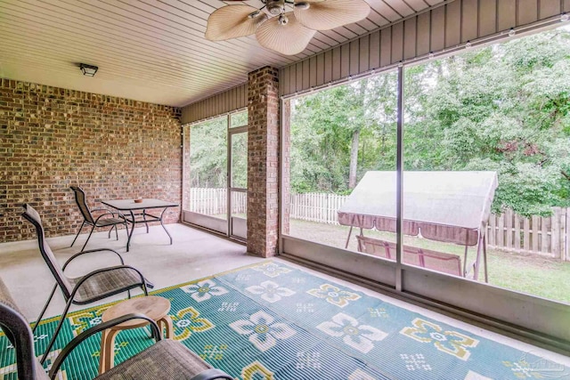 unfurnished sunroom featuring ceiling fan