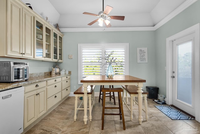 kitchen with a healthy amount of sunlight, light stone countertops, white dishwasher, and cream cabinets