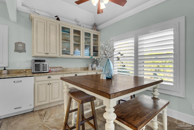 kitchen with ceiling fan, dishwasher, light stone countertops, ornamental molding, and cream cabinets