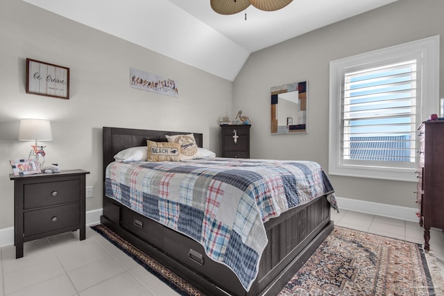 bedroom featuring ceiling fan, light tile patterned floors, and vaulted ceiling