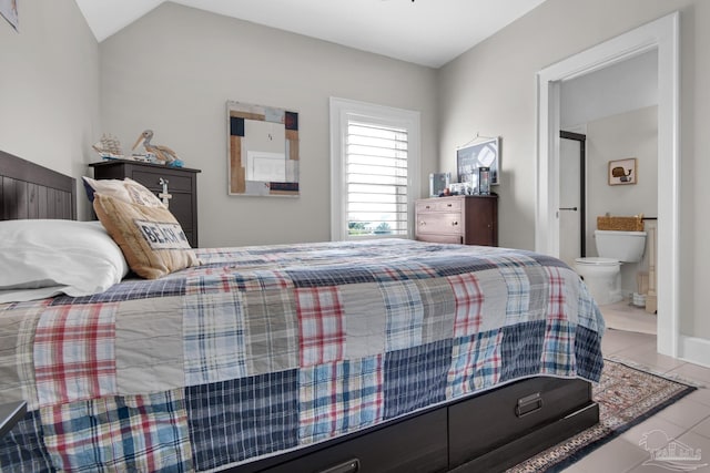 bedroom with ensuite bathroom, lofted ceiling, and tile patterned flooring