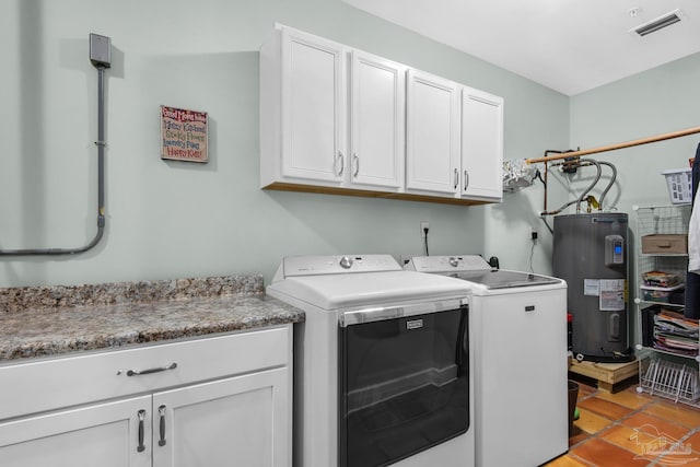 laundry room featuring water heater, light tile patterned flooring, washing machine and dryer, and cabinets