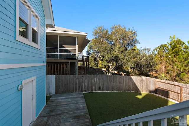 view of yard featuring a deck and a sunroom