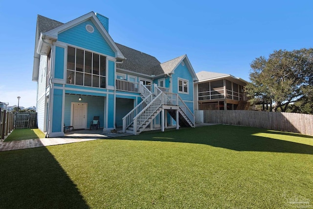 back of house with a sunroom and a yard