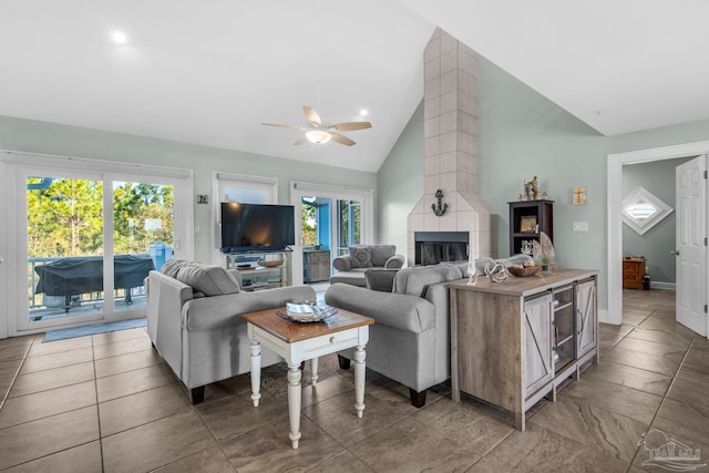 tiled living room with ceiling fan, a fireplace, plenty of natural light, and high vaulted ceiling