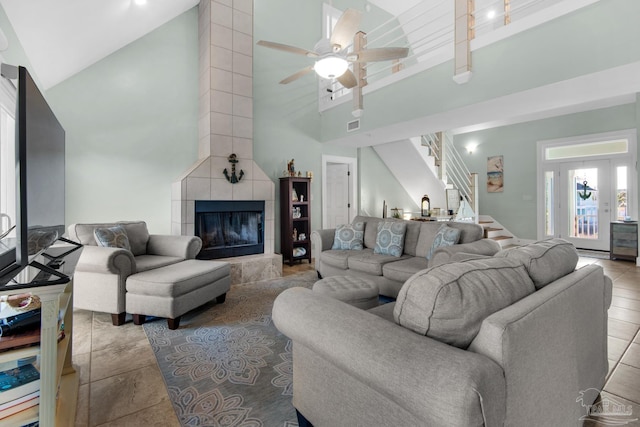 living room with high vaulted ceiling, light tile patterned floors, ceiling fan, and a fireplace