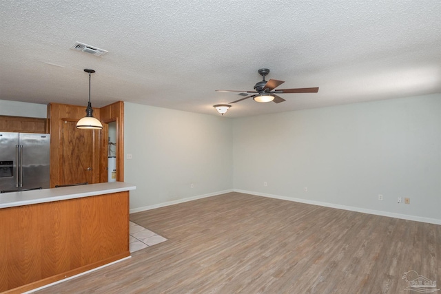 7026 Balboa Dr, Pensacola, FL 32526 - unfurnished living room with light wood finished floors, a ceiling fan, and a textured ceiling