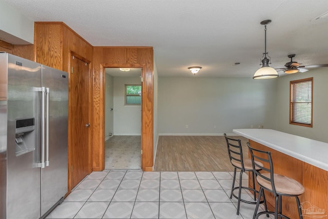 7026 Balboa Dr, Pensacola, FL 32526 - kitchen featuring high quality fridge, healthy amount of natural light, a ceiling fan, and brown cabinetry