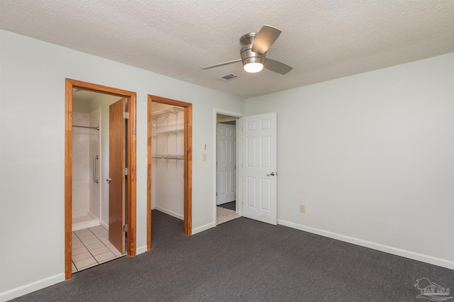 7026 Balboa Dr, Pensacola, FL 32526 - unfurnished bedroom with dark colored carpet, a closet, a textured ceiling, a spacious closet, and a ceiling fan