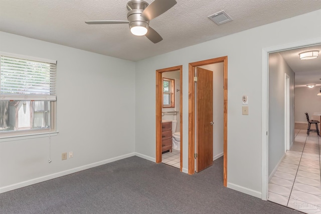 7026 Balboa Dr, Pensacola, FL 32526 - unfurnished bedroom featuring connected bathroom, a textured ceiling, carpet floors, and a ceiling fan