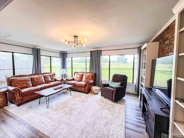 4718 Huron Dr, Pensacola, FL 32507 - living room featuring wood finished floors, a chandelier, plenty of natural light, a textured ceiling, and crown molding