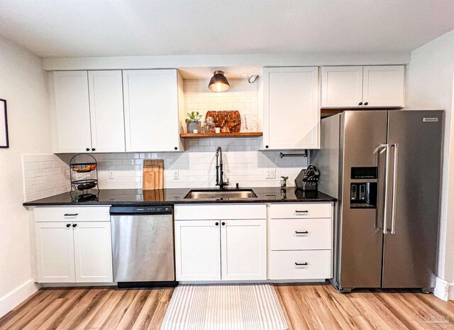 4718 Huron Dr, Pensacola, FL 32507 - kitchen with stainless steel appliances, a sink, light wood-style flooring, and white cabinets