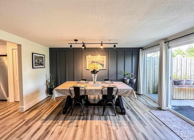 4718 Huron Dr, Pensacola, FL 32507 - dining space featuring track lighting, light wood finished floors, baseboards, and a textured ceiling