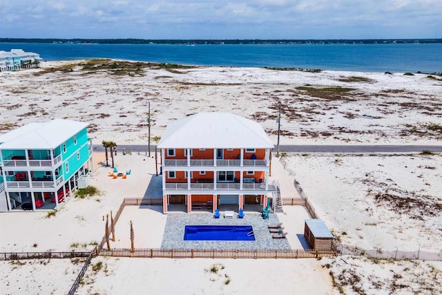 drone / aerial view featuring a beach view and a water view