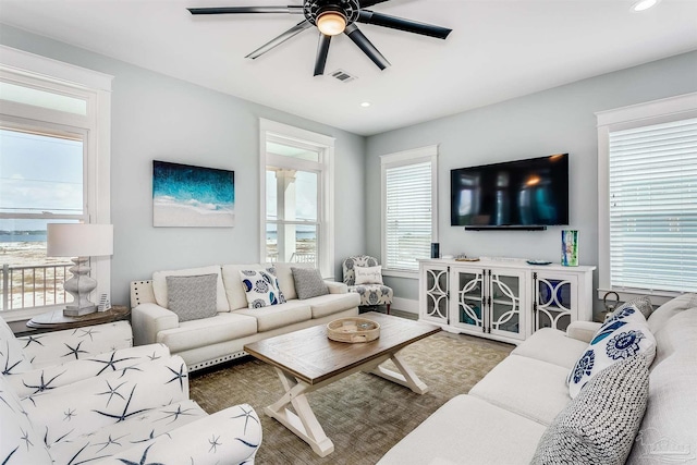 living room with ceiling fan, visible vents, baseboards, and recessed lighting