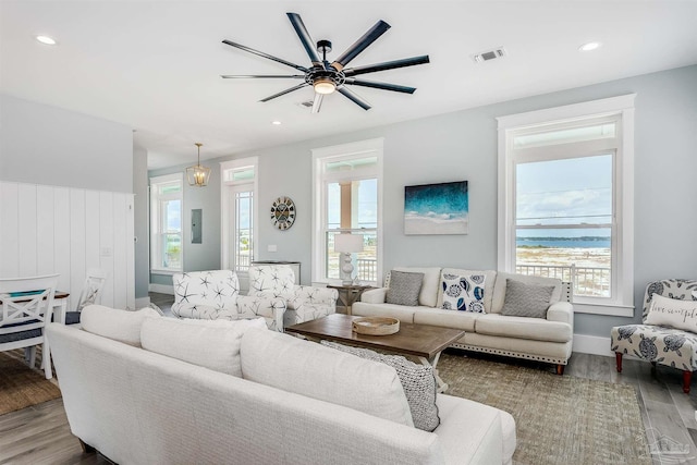 living room with electric panel, wood finished floors, visible vents, and recessed lighting