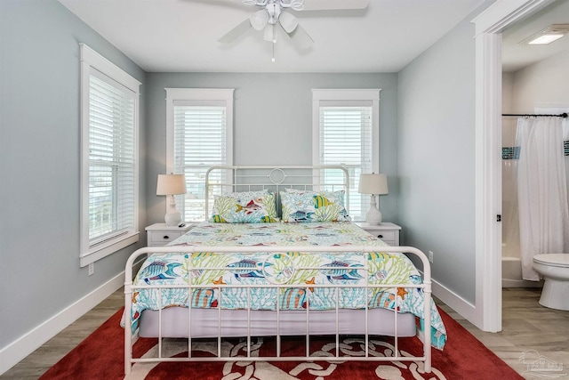 bedroom with ceiling fan, wood finished floors, visible vents, and baseboards