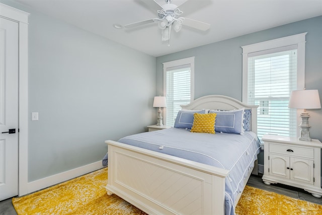 bedroom with light wood finished floors, baseboards, and a ceiling fan