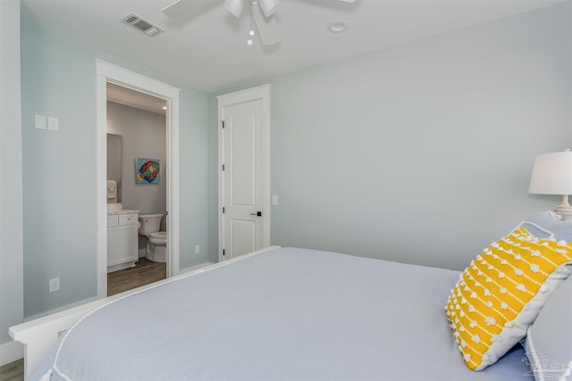 bedroom with a ceiling fan, visible vents, connected bathroom, and wood finished floors