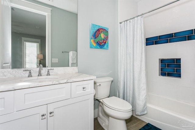 full bathroom with wood finished floors, shower / bath combo, vanity, and toilet