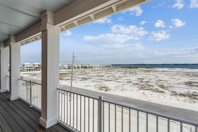 balcony with a water view and a view of the beach