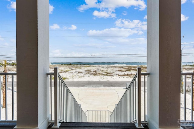 balcony with a water view and a beach view