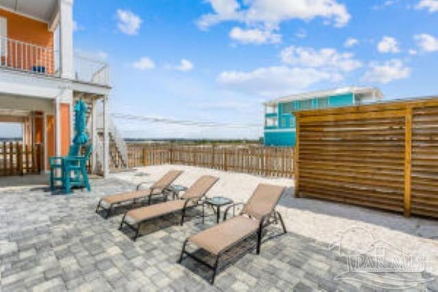 view of patio / terrace with fence and a balcony