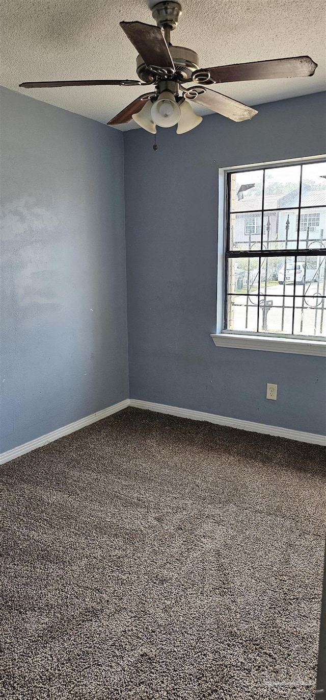 empty room with ceiling fan and a textured ceiling