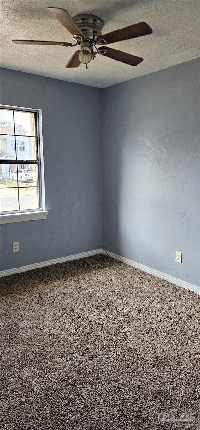 carpeted spare room with ceiling fan and a textured ceiling