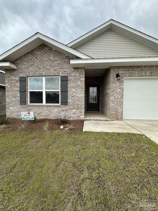 1644 Slate Dr, Cantonment, FL 32533 - ranch-style home with brick siding, an attached garage, a front yard, and driveway