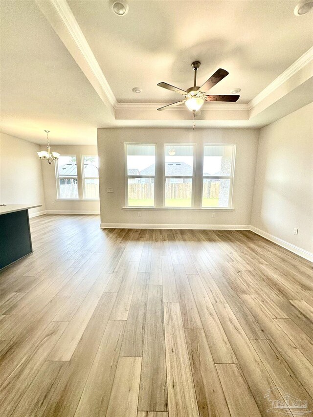 1644 Slate Dr, Cantonment, FL 32533 - unfurnished living room featuring a raised ceiling, ornamental molding, a chandelier, and light wood finished floors