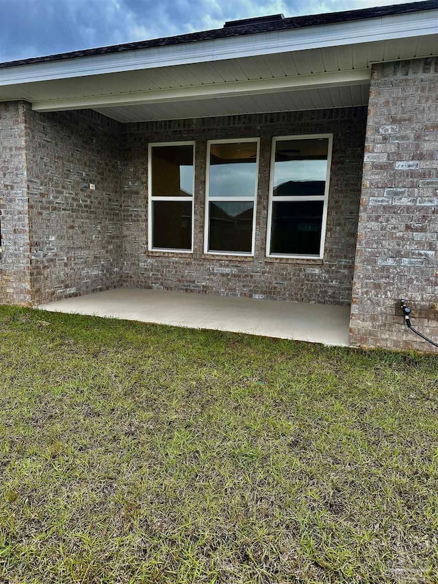 1644 Slate Dr, Cantonment, FL 32533 - property entrance featuring brick siding, a patio area, and a lawn