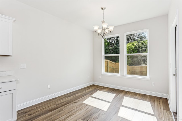 1644 Slate Dr, Cantonment, FL 32533 - unfurnished dining area featuring a chandelier, light wood finished floors, and baseboards