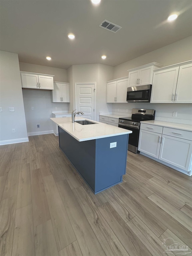 1644 Slate Dr, Cantonment, FL 32533 - kitchen with stainless steel appliances, a sink, white cabinetry, light wood-type flooring, and recessed lighting