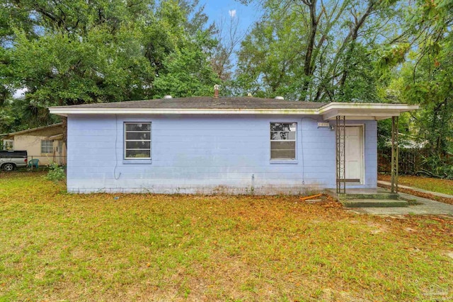 view of side of home with a yard