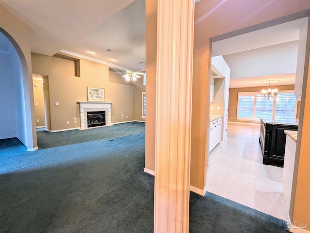 unfurnished living room with a tile fireplace, dark colored carpet, and ceiling fan with notable chandelier