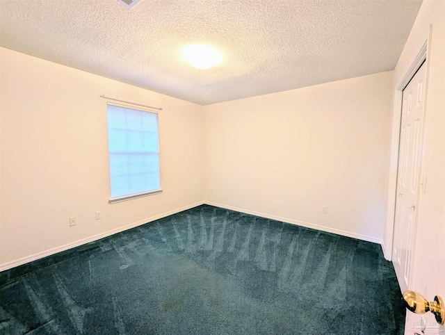 unfurnished room featuring dark carpet and a textured ceiling